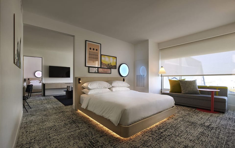 Unwind in a sleek, sunlit bedroom with glowing ambience.