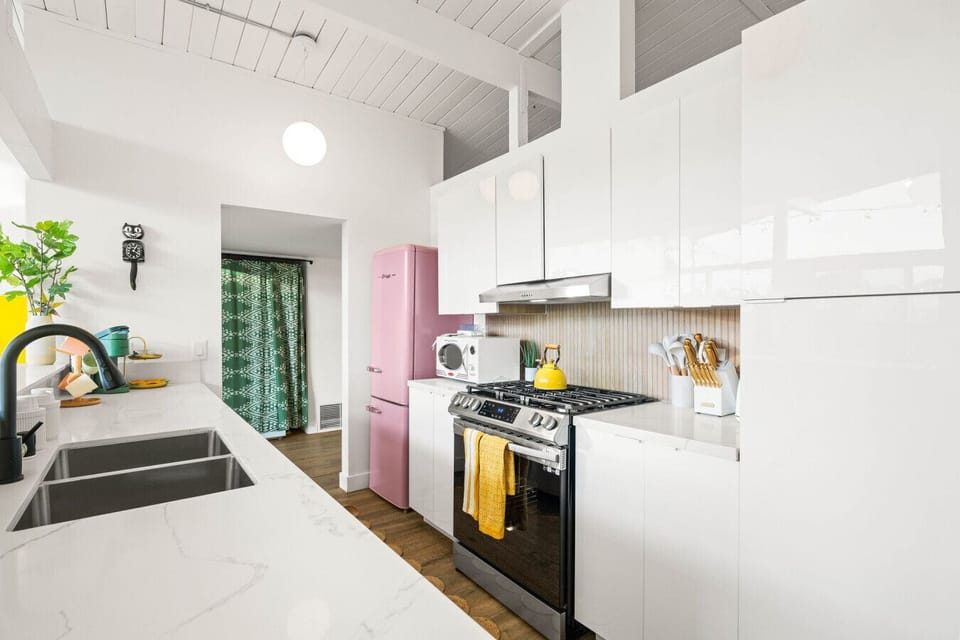 Cook in style with this sleek, modern kitchen featuring retro flair and vibrant pops of color.