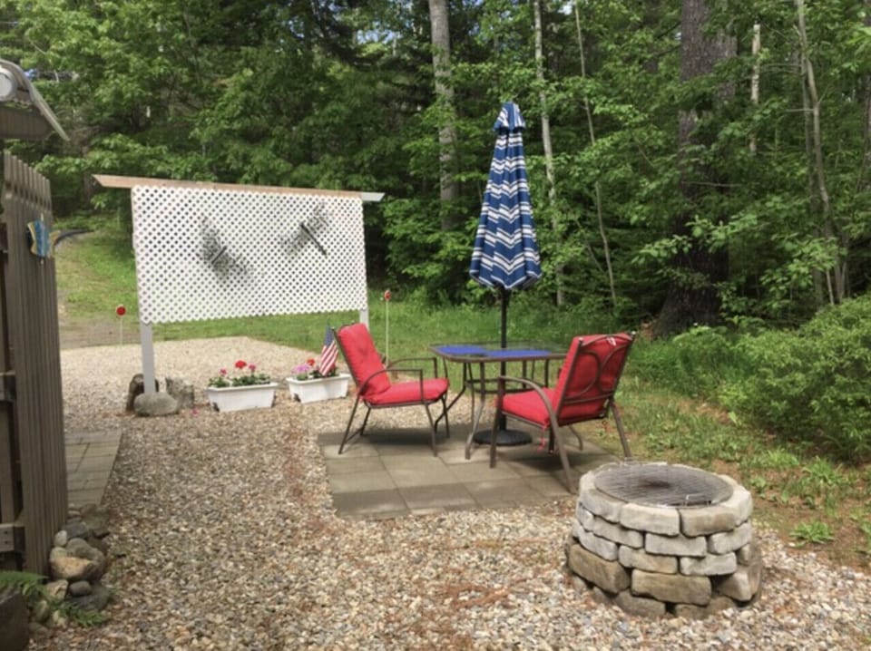 Kick back in the peaceful backyard patio with comfy chairs, a fire pit, and outdoor dining under the trees and stars!