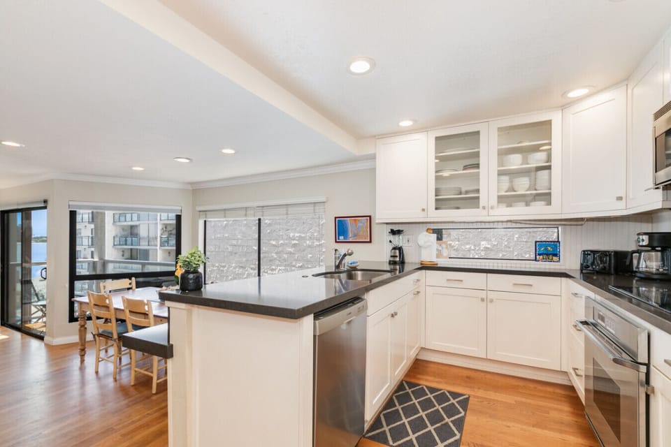Cook and connect with the group in this open-concept kitchen featuring granite countertops and panoramic windows.