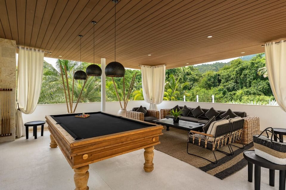 Covered outdoor terrace with pool table and stunning tropical hillside views