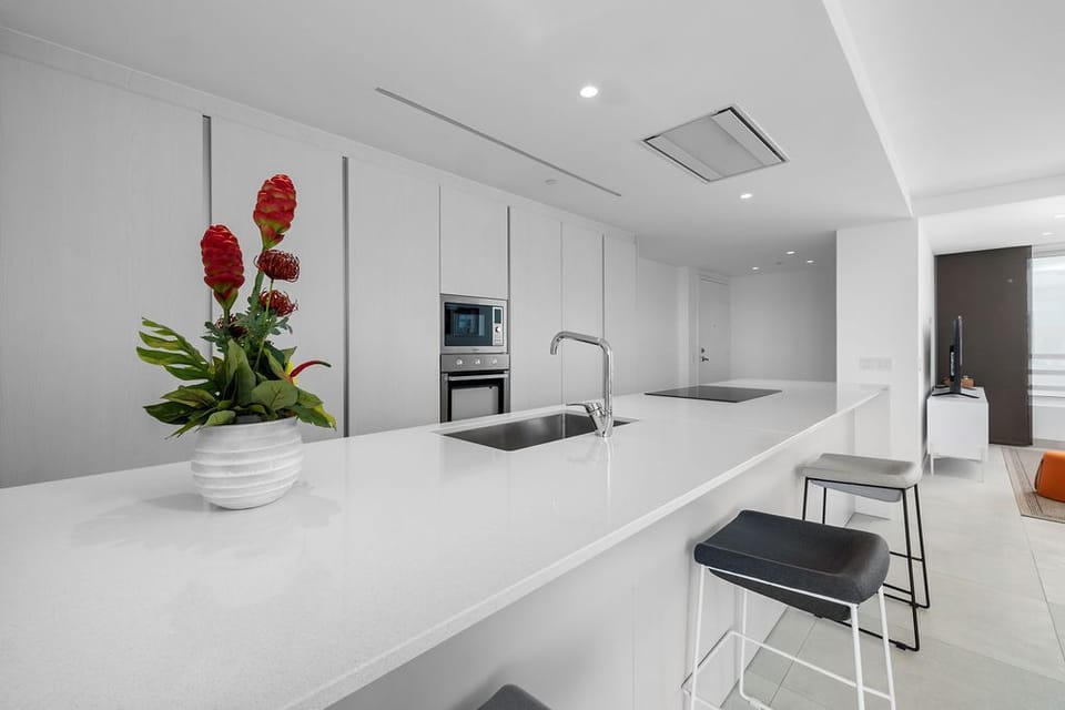 Your sleek, modern kitchen awaits with pristine countertops, premium appliances, and an inviting breakfast bar perfect for morning coffee or casual meals.