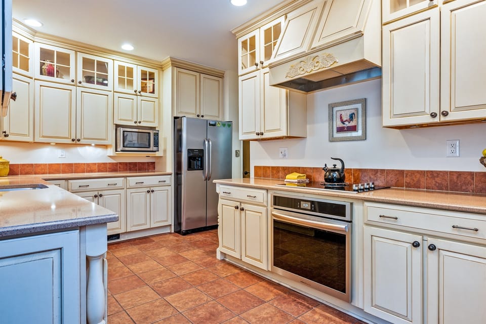 Elegant chef’s kitchen featuring custom cabinetry, granite counters, and stainless-steel appliances—perfect for cooking and gathering.