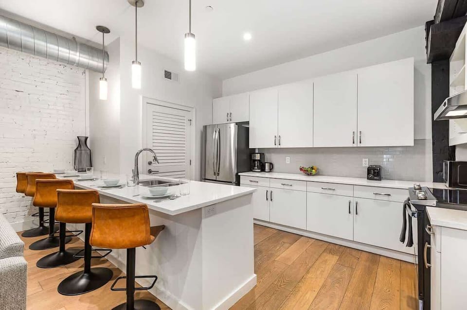 Fully equipped kitchen featuring stainless steel appliances, open counter space, and bar seating for 5 guests.