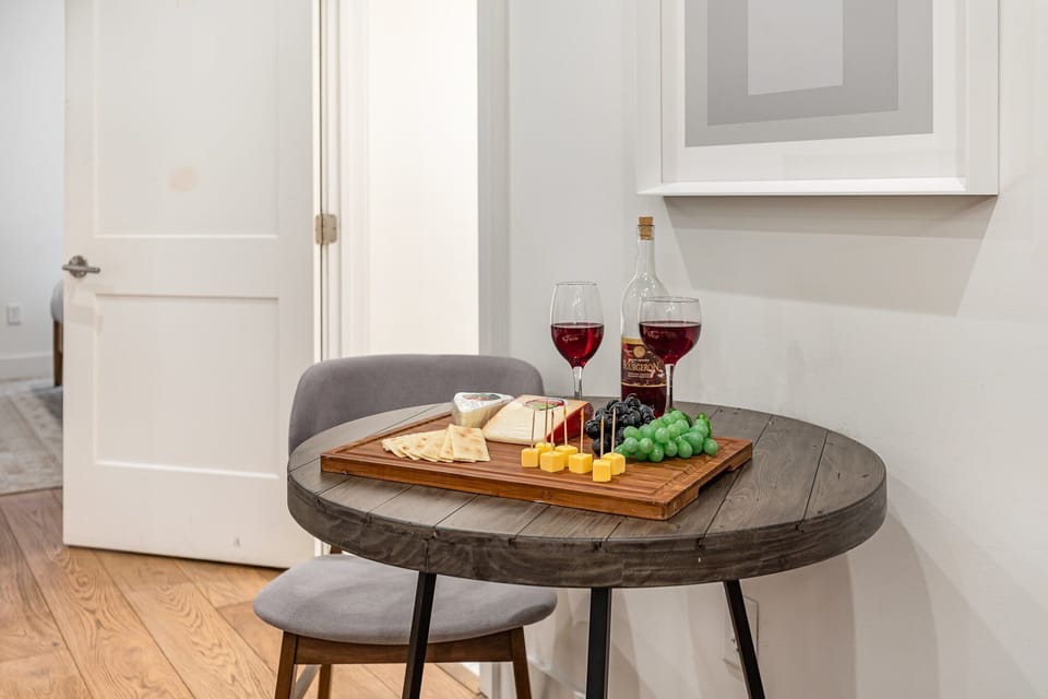 Unit 2: Open-concept living area featuring cozy furnishings, smart TV, small dining area with seating for 2 guests, and a sleeper sofa.