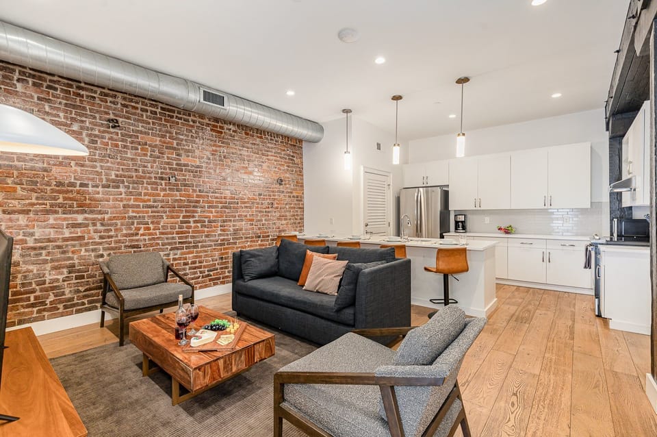 Unit 1: Open-concept living area featuring cozy furnishings, smart TV, and a sleeper sofa.