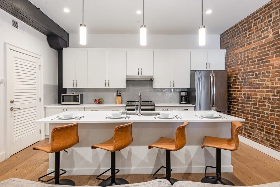 Unit 2: The kitchen features stainless steel appliances, a large island, and breakfast bar seating for four—ideal for casual dining.