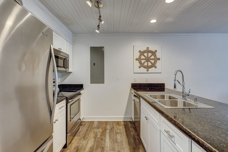 Fully stocked kitchen featuring all stainless steel appliances.