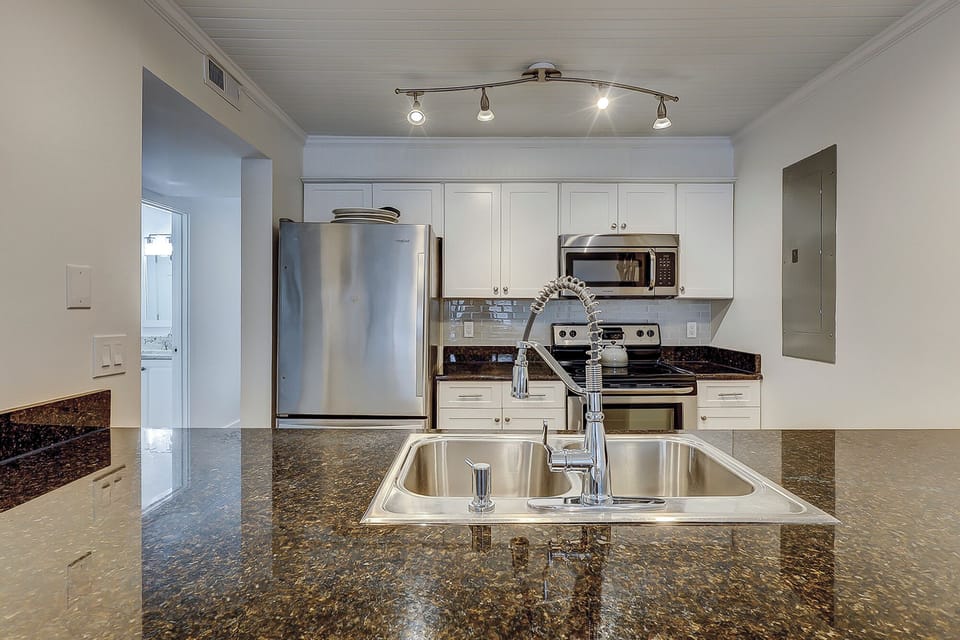 Fully stocked kitchen featuring all stainless steel appliances.