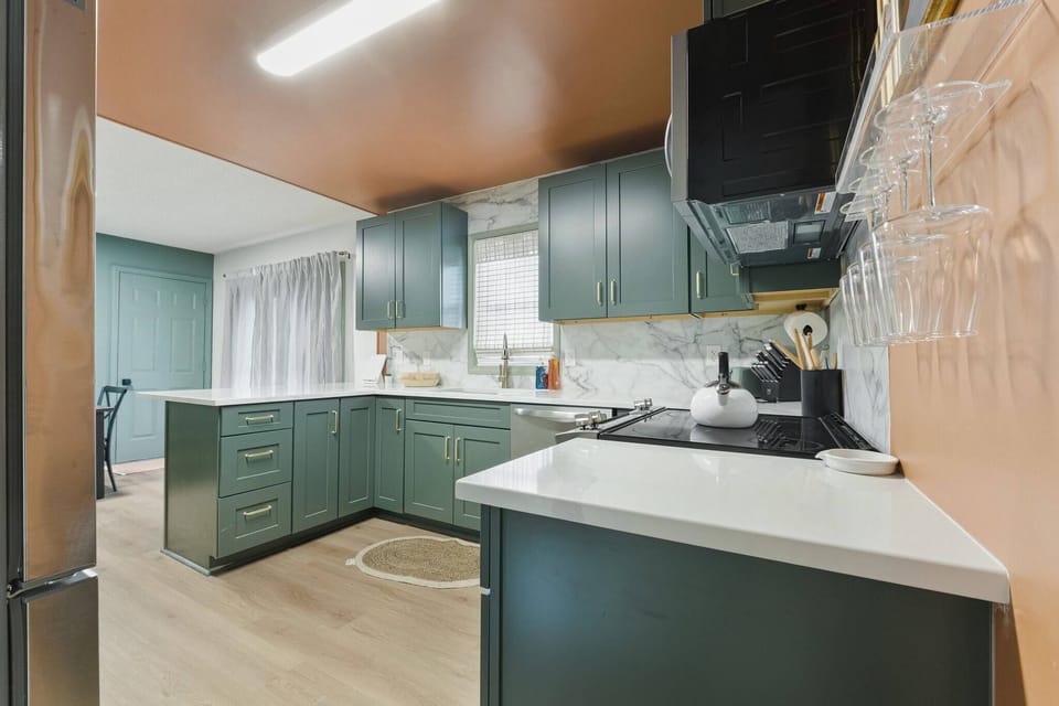 Fully equipped kitchen with an electric stove/oven combo with overhead microwave. 