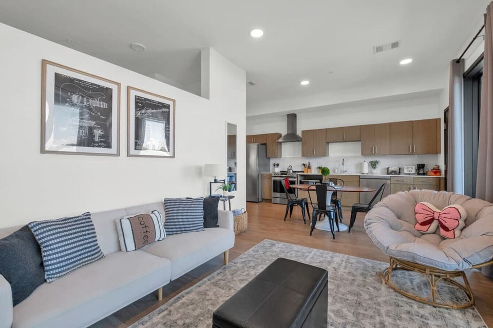 - Modern open concept living room with designer decor and natural light   - Fully equipped kitchen with stainless steel appliances and dining area   - Stylish urban apartment near downtown attractions and top restaurants