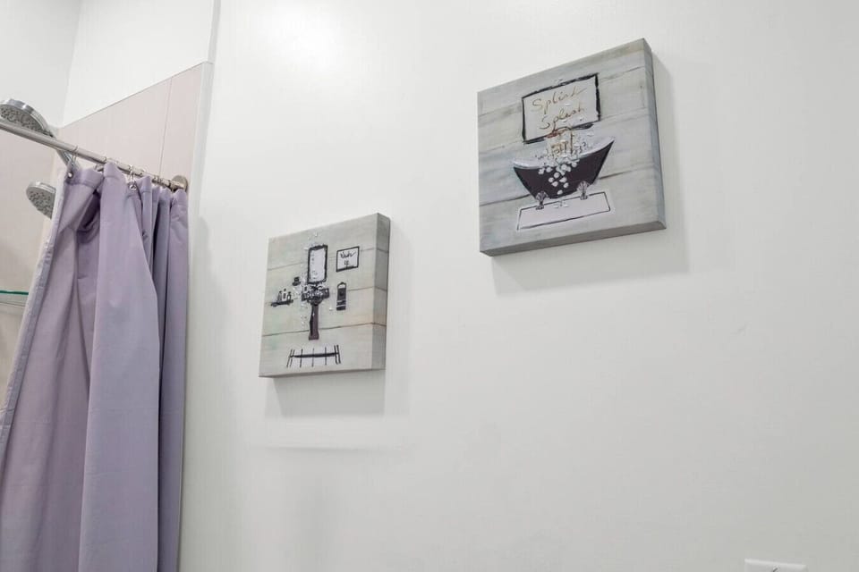 - Decorative bathroom wall art with spa themed accents   - Neutral color palette with soft lighting and clean lines   - Thoughtfully styled space with calming atmosphere