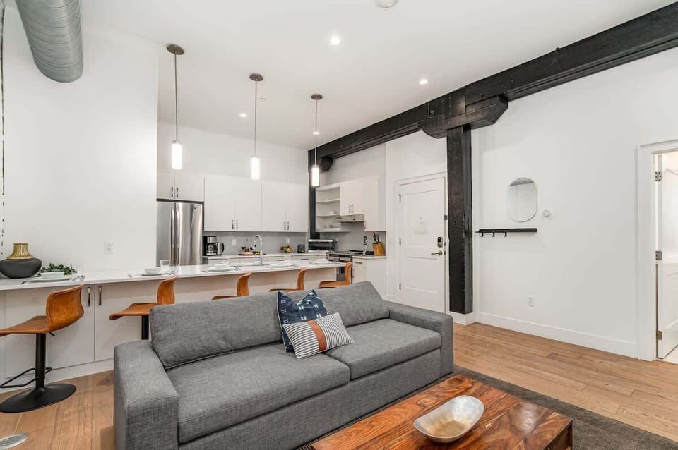 Unit 1: Open-concept living area featuring cozy furnishings, smart TV, and a sleeper sofa.