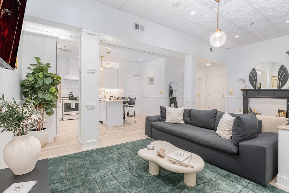 Unit 1: Open-Concept Living Area featuring designer furnishings, and a Smart TV.