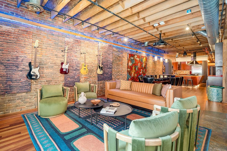 Unit 2: Main Living Area featuring designer furnishings, TV Projector, piano, electric guitars, and electronic Window Curtains