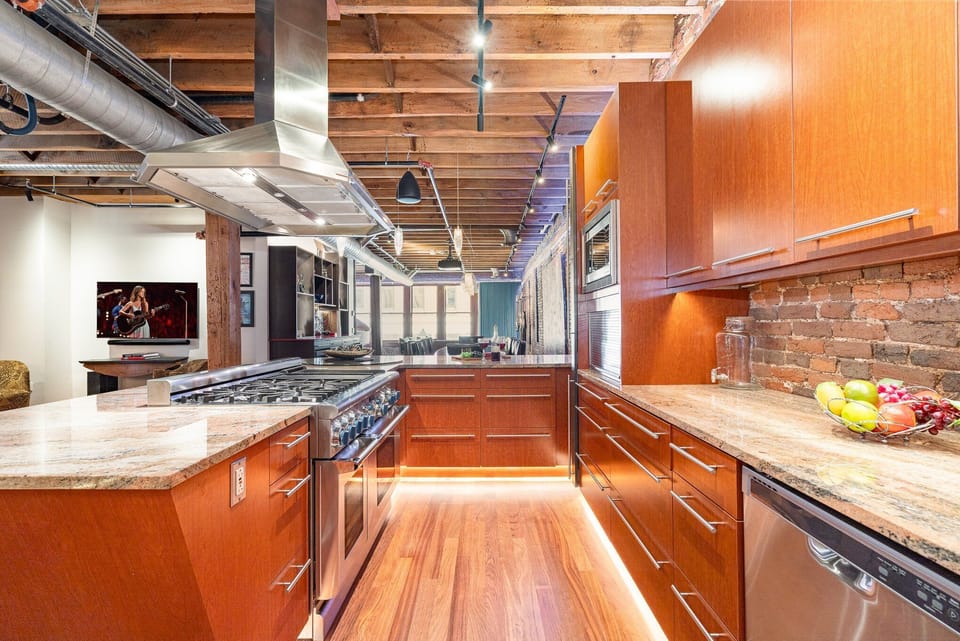 Unit 2: Fully Equipped Kitchen featuring stainless steel, open counter space, and bar seating for 3 guests.