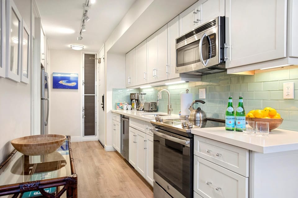 This coastal-cutie kitchen features sea-glass backsplash, crisp white cabinets, and charm that shines like sunshine     MKV-B247
