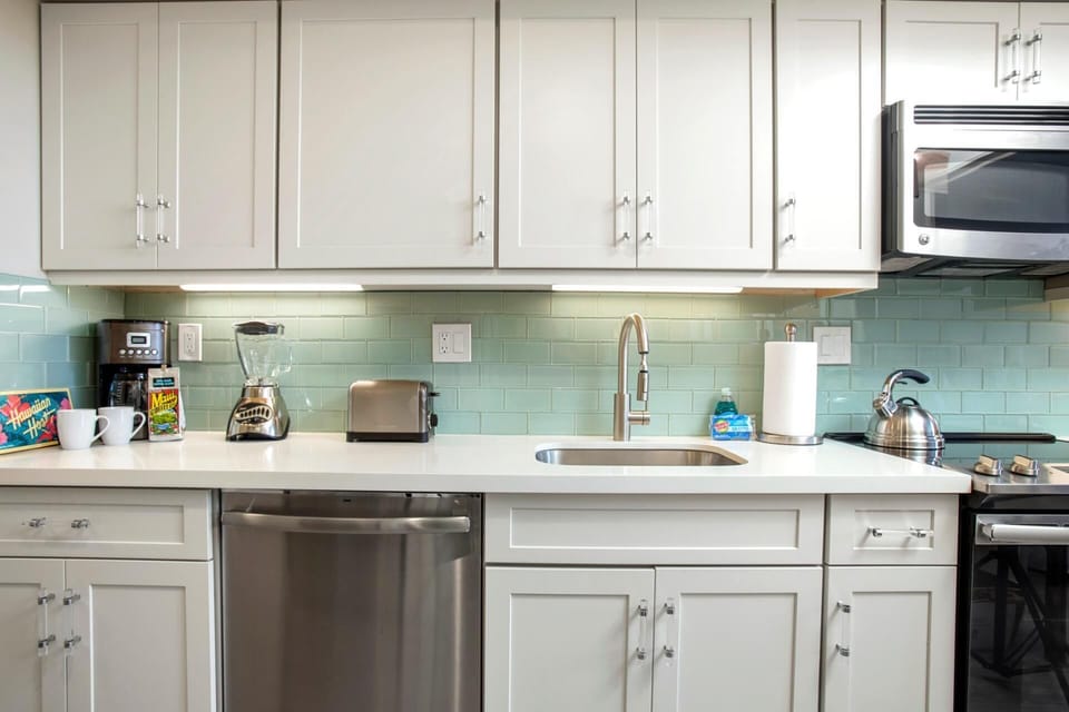 Aqua tiles, cloud-white cabinets, and beachy vibes make this galley kitchen a fresh and cheerful cooking escape     MKV-B247