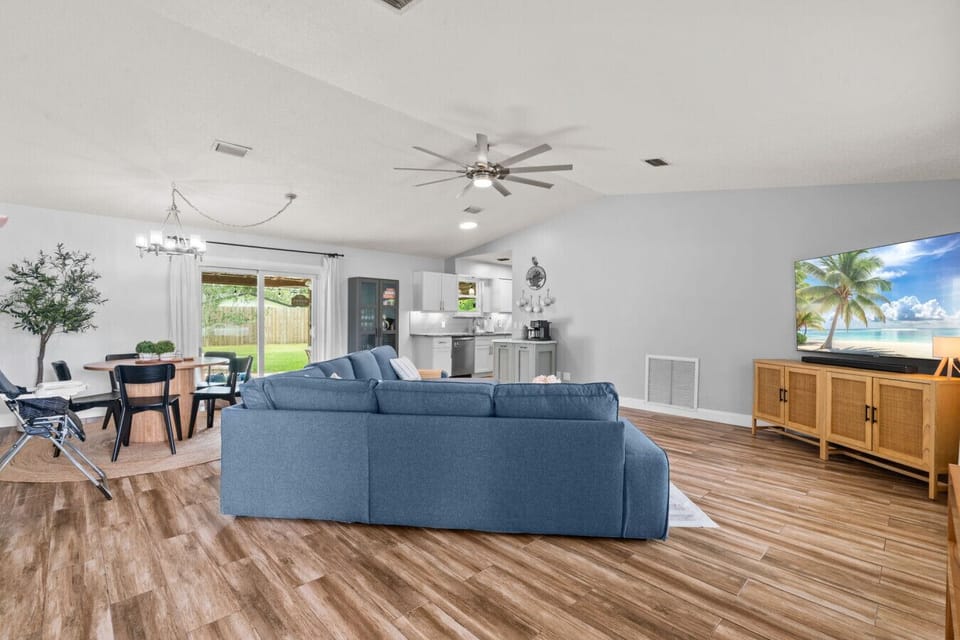 Relax in the airy living room with a comfy sectional, Smart TV, and open layout — with seamless flow to the backyard through sliding glass doors.