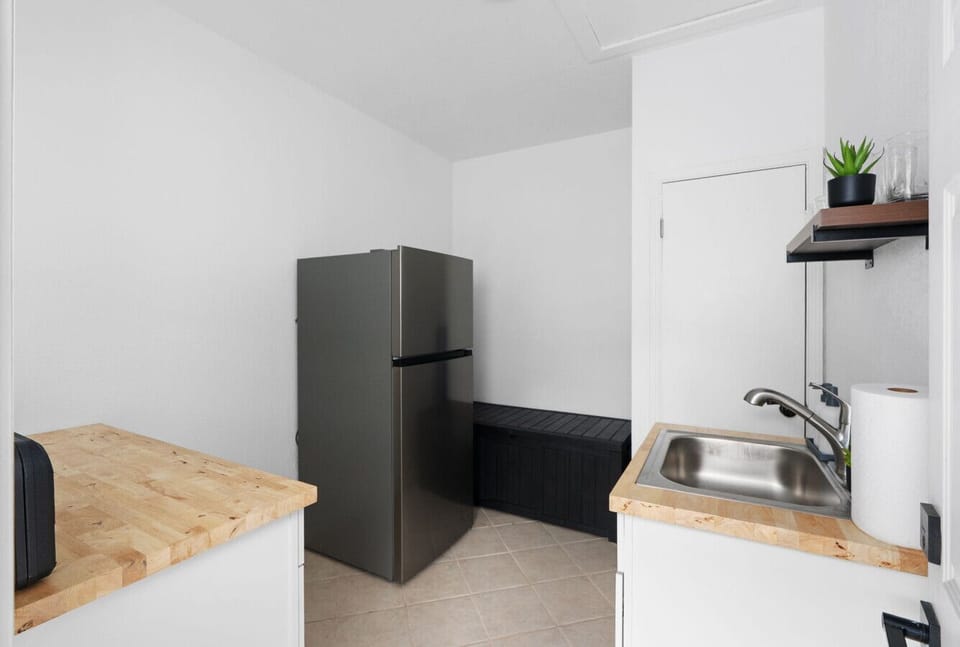 Convenient kitchenette space with full-size fridge, prep counters, and sink—ideal for storing snacks or preparing light meals during your stay