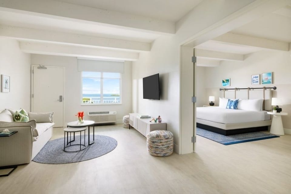 Flow between lounge and sleep spaces in one breezy suite.
