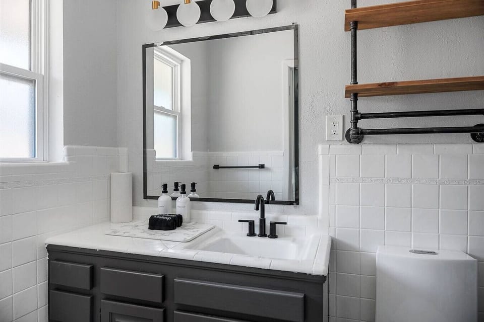 Modern bathroom with sleek black fixtures, bright lighting, and complimentary toiletries for your stay.