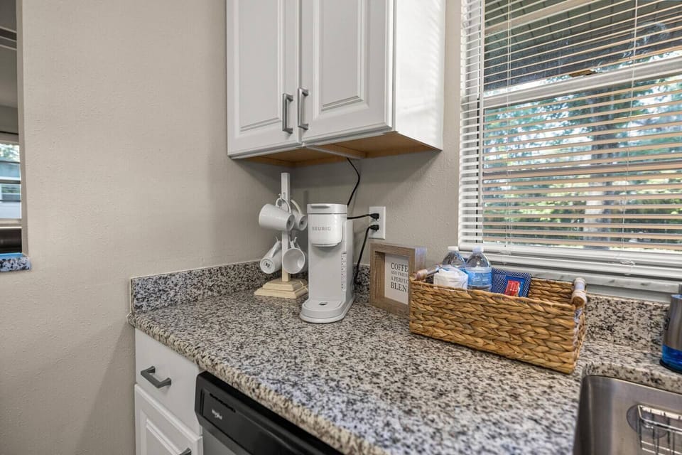 Coffee station with mugs, water, and tissues — cozy setup by the window with natural light