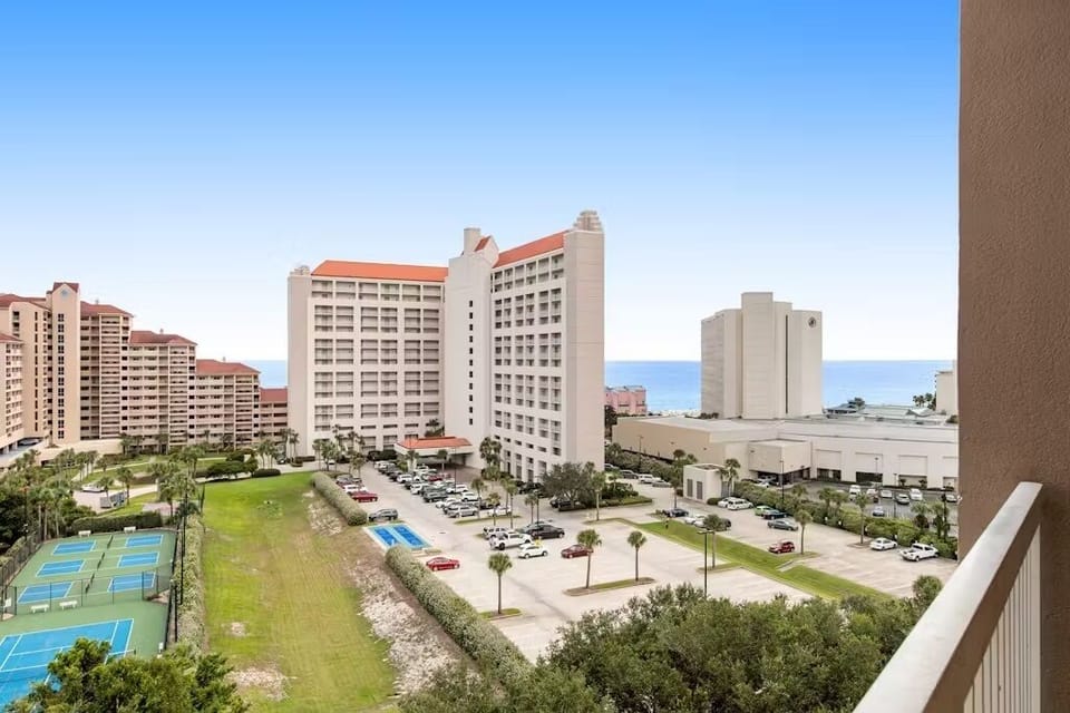 Resort complex featuring multiple buildings, recreational facilities, and ocean proximity for a complete vacation destination.
