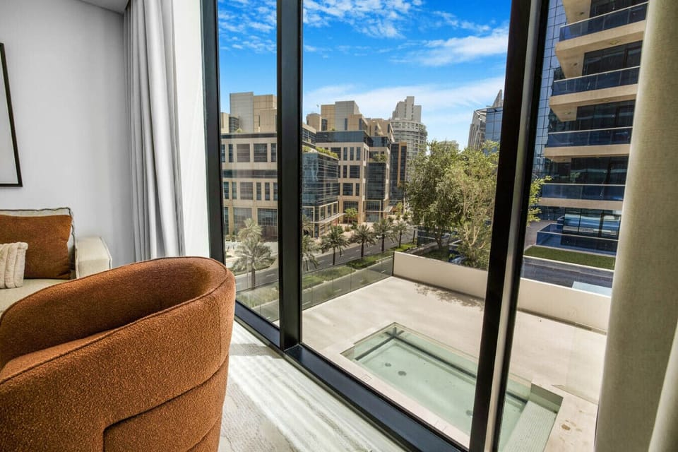 Window view of modern buildings and a private plunge pool