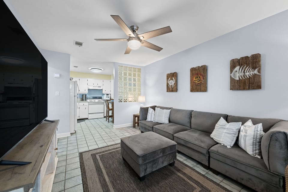 The spacious sectional sofa flows effortlessly into a fully equipped kitchen, ideal for entertaining or keeping an eye on dinner while lounging.
