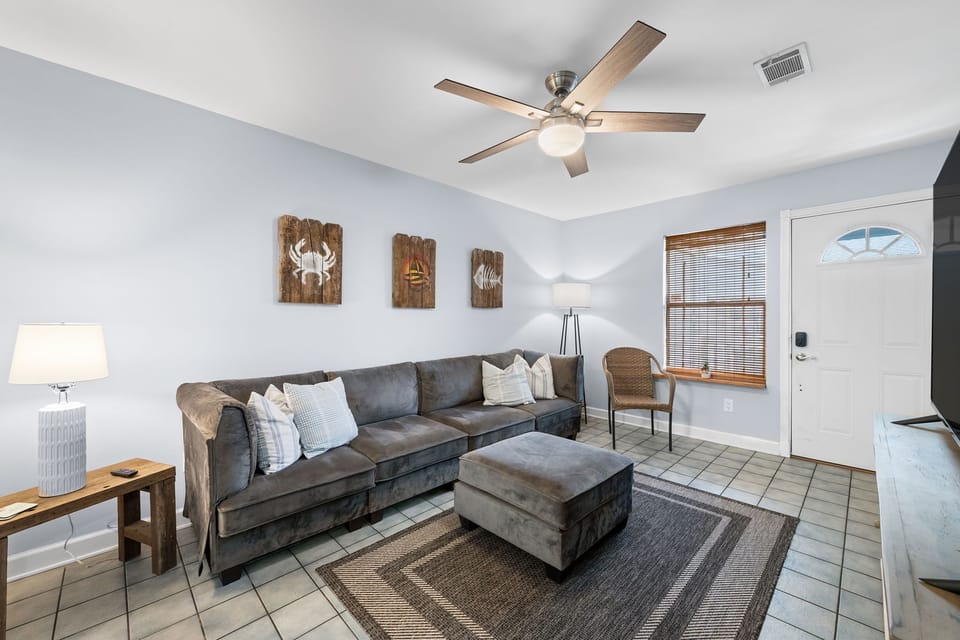 This charming living room invites you to unwind with its plush sectional sofa, warm lighting, and calming neutral tones.