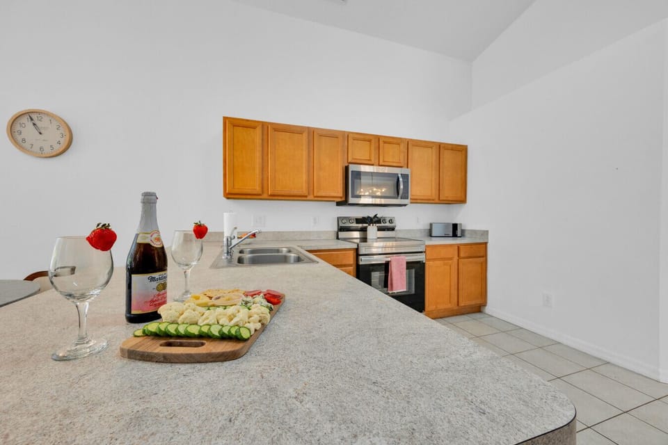 Kitchen | Spacious layout with stainless steel appliances, island counter, and pool view
