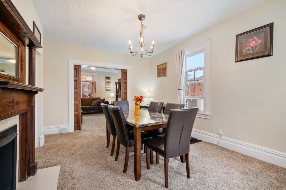 Spacious dining room with two windows and AC unit.