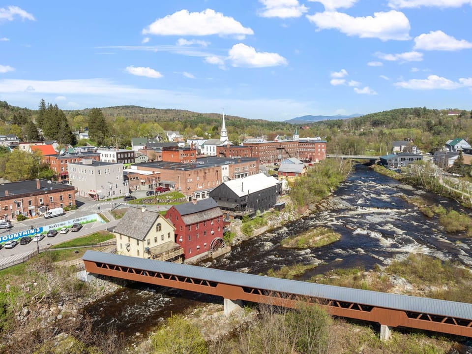 A sunny view of the covered bridge and riverfront - the perfect backdrop for a scenic stroll or local craft beer.