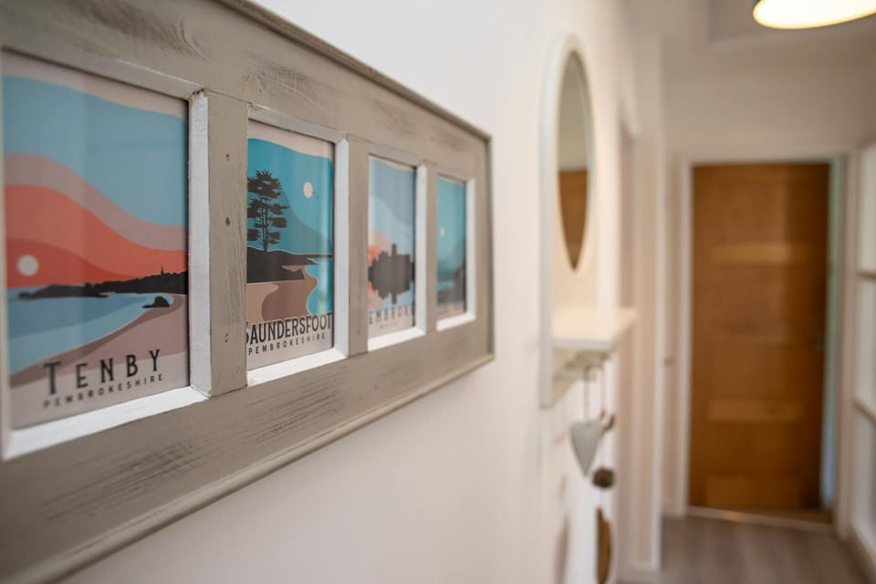 Hallway with local artwork and wall mounted mirror with shelf below