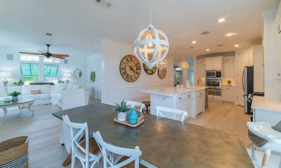 Full kitchen with bar seating, stainless steel appliances, and elegant pendant lights.