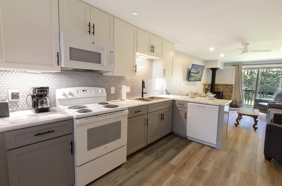 The newly updated kitchen features stunning cabinetry and ample countertop space, perfect for preparing a quick snack or a delicious meal.