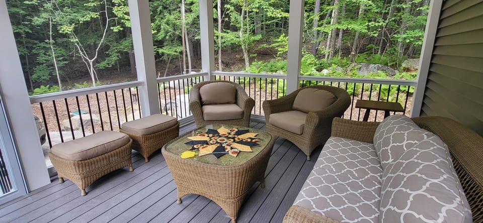 Screen Porch with comfortable furniture and a ceiling fan. 