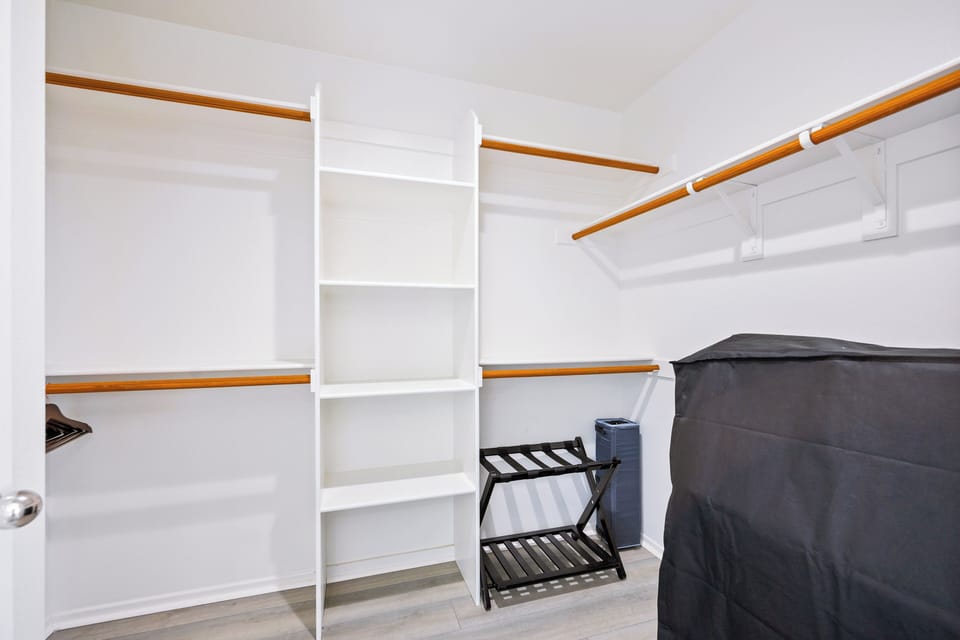 Spacious walk-in closet with built-in shelving and hanging space.
