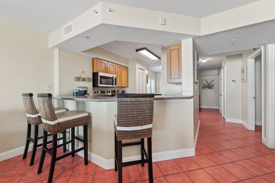 The fully equipped kitchen includes bar stool seating at the counter—perfect for breakfast and quick bites