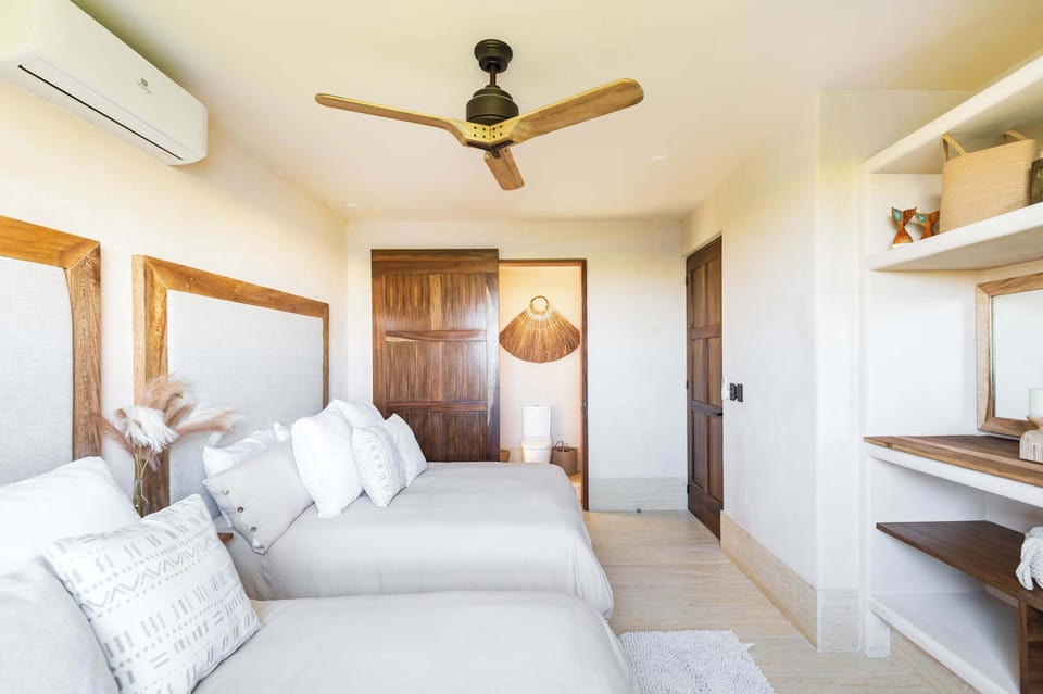 Habitación 3 con dos camas queen, vistas al mar. Cuenta con baño privado, AC, ventilador en techo y armario 