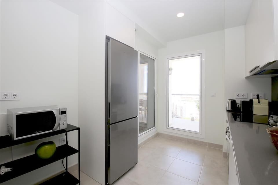 Kitchen from another angle with laundry room and terrace access to the rear