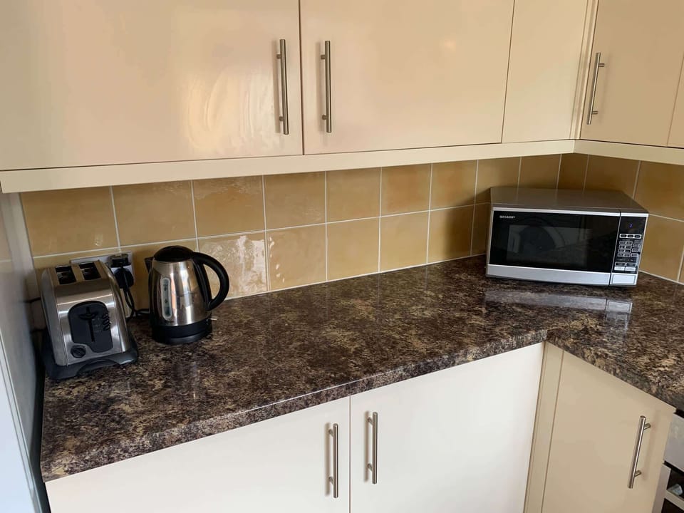 Toaster, kettle and microwave in fully equipped kitchen