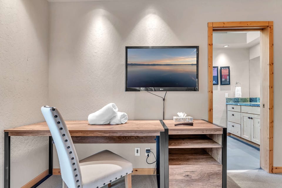Bedroom 1: King bed, main floor, en-suite bathroom with standing shower, dedicated workspace, Smart TV