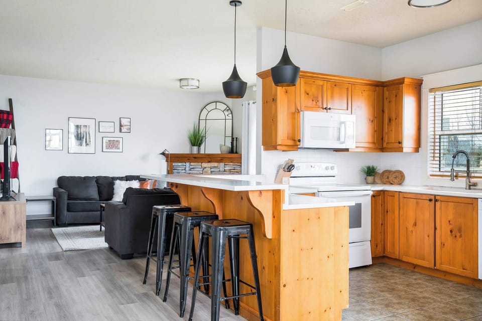 Bright & welcoming kitchen complete with new quartz counters, bar stools, and cooking utensils required to feel right at home!