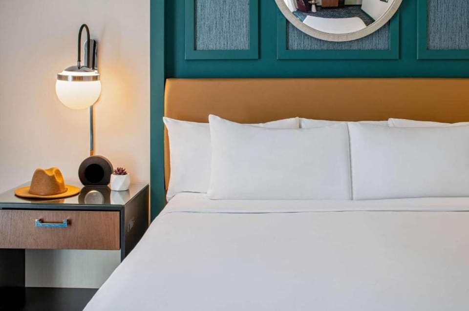 Cozy bedroom with white pillows and a nightstand.