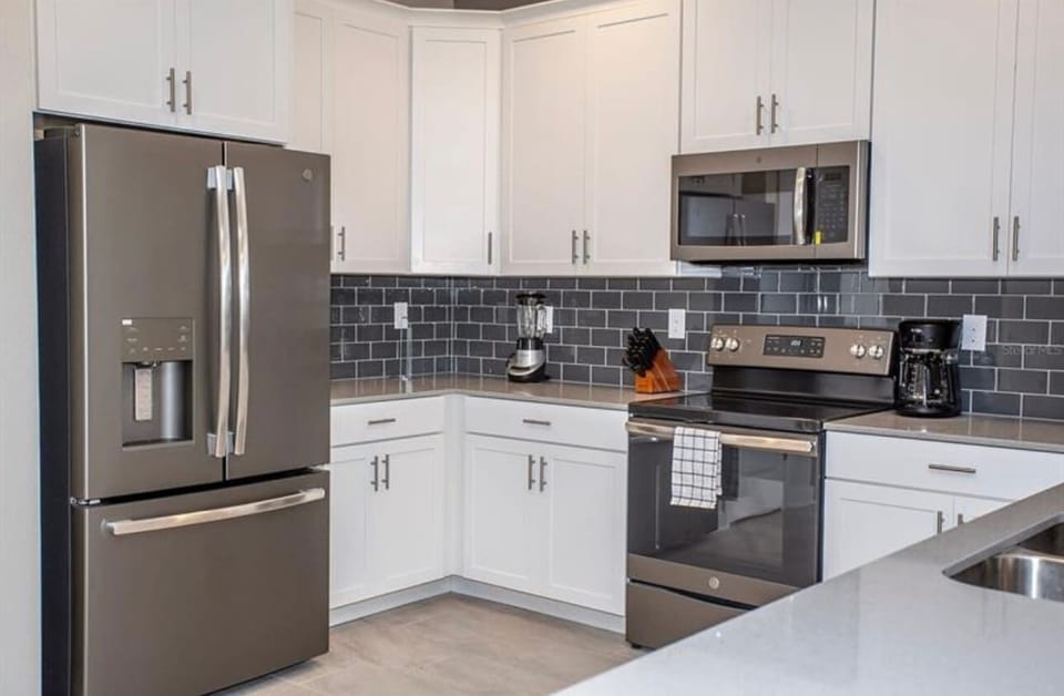 Whip up your favorite meals in this stylish, fully stocked kitchen featuring stainless steel appliances, cookware, and a spacious layout — perfect for family breakfasts or gourmet dinners