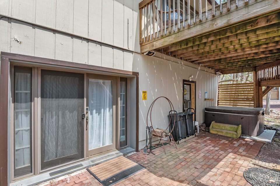 Unwind on the covered porch with bench seating overlooking the peaceful wooded backyard