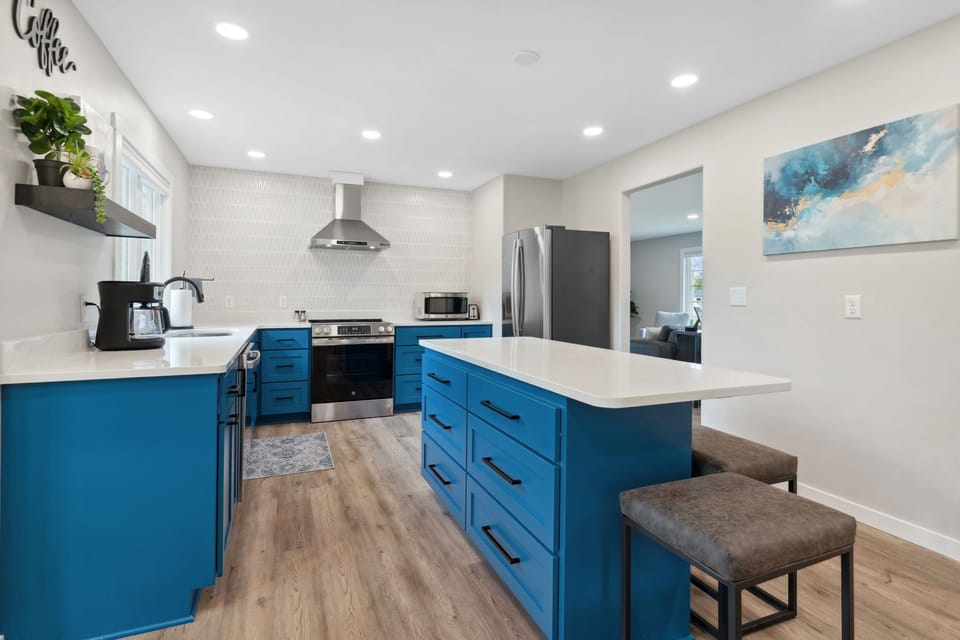 Whip up your favorite meals in this stunning blue kitchen, featuring sleek countertops, modern appliances, and a coffee bar ready for your morning brew.