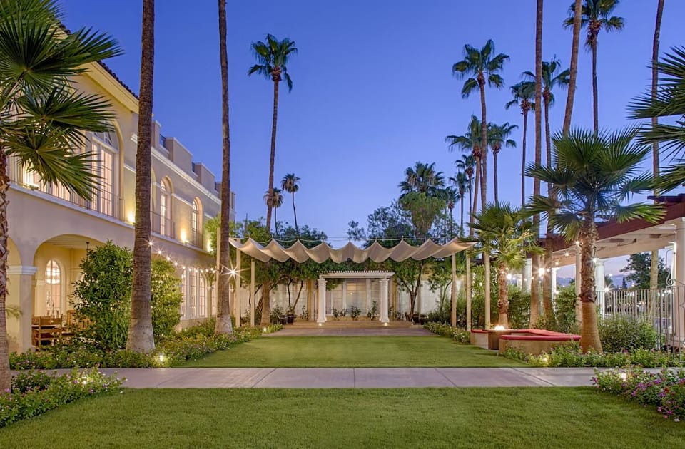 Stroll through palm-lined gardens as evening lights begin to glow.